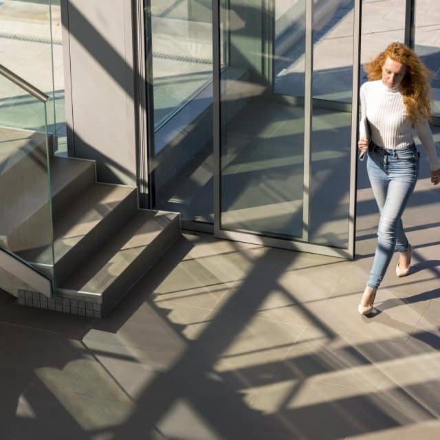 Femme passant une porte vitrée motorisée